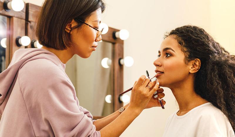Once you learn how much do makeup artists make, you can work as a makeup artist, like this woman working on a client.
