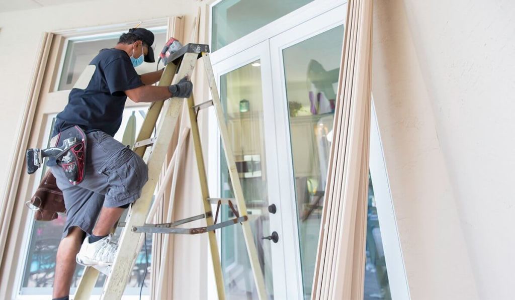 Getting a contractor’s license in Maine lets you work in clients’ homes, like this contractor installing patio doors.