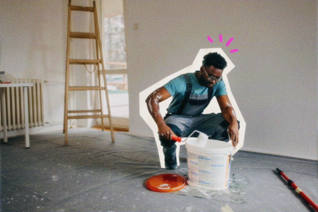 Painter dipping a roller into a paint bucker