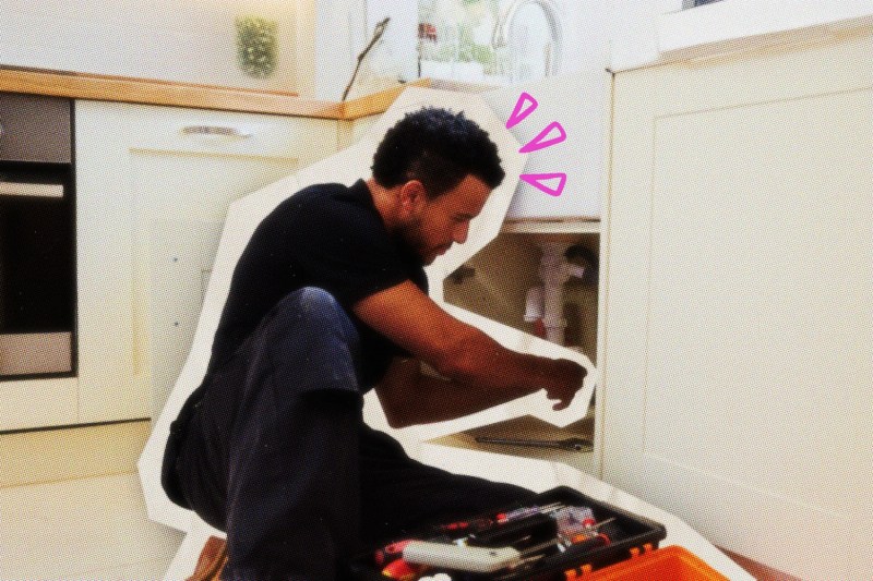 Plumber working under a kitchen sink