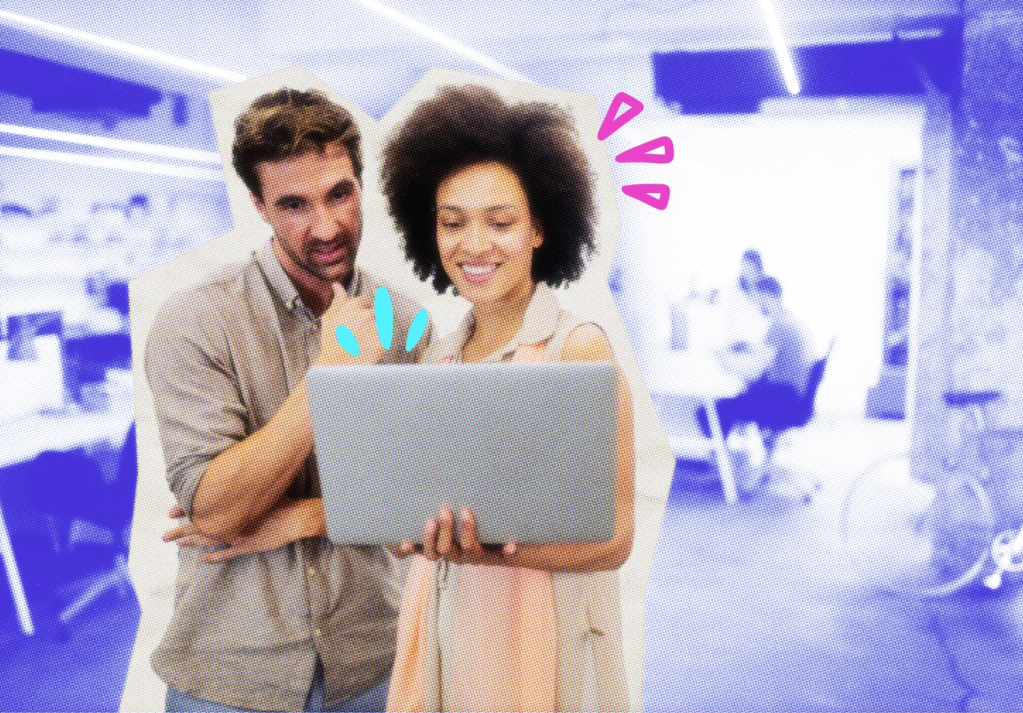 two business owners stand looking at a laptop