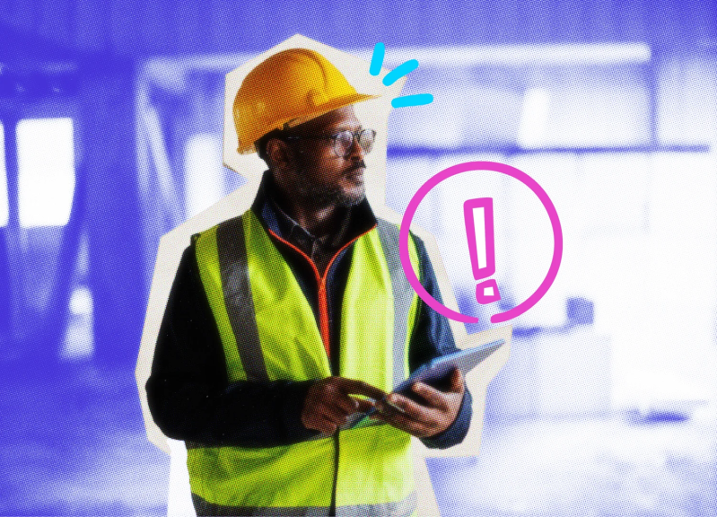 Man wearing a hardhat and fluorescent vest holding a tablet