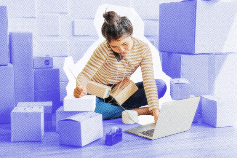 E-commerce business owner talking on the phone while working on a laptop