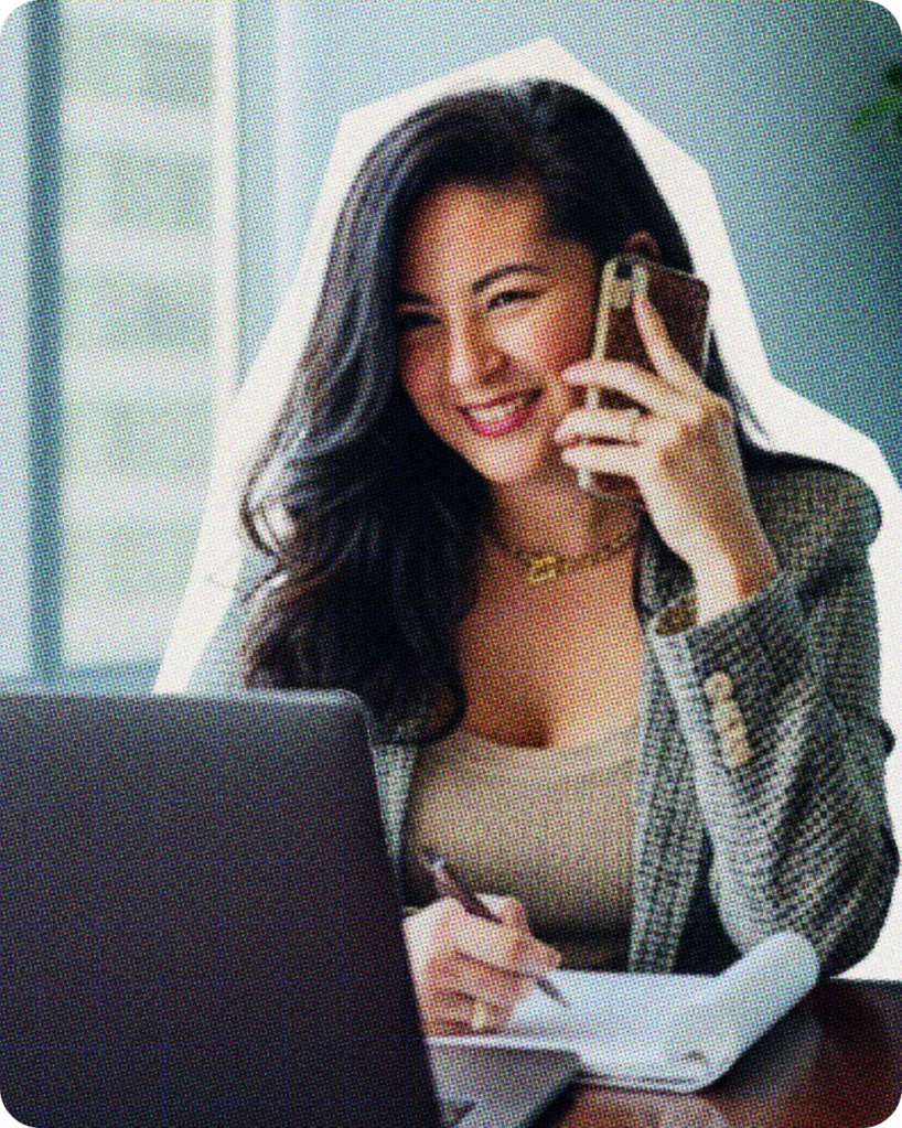 Woman working on a laptop talking on a cellphone