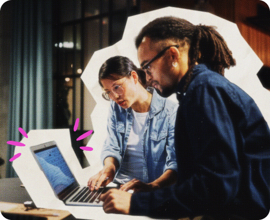 A man and a woman work together on a laptop.