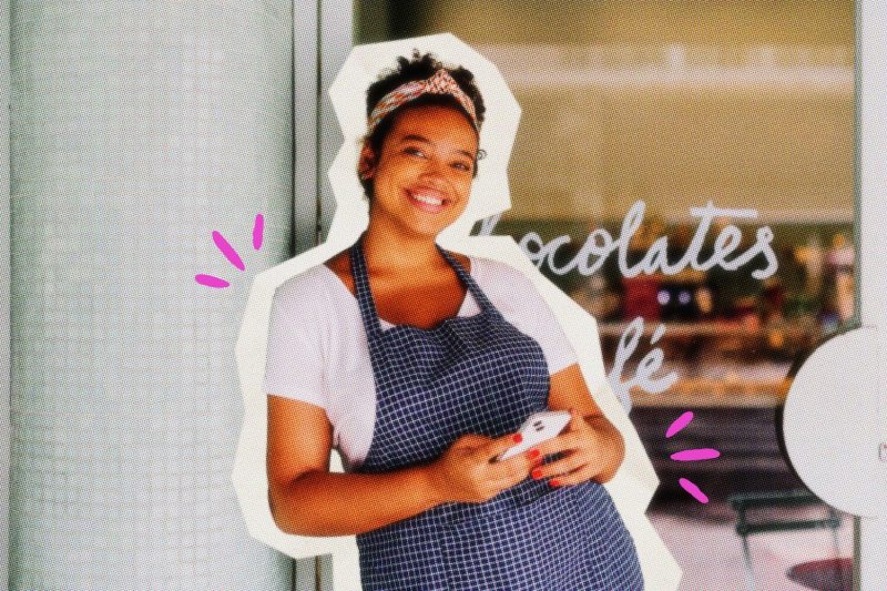 Smiling solopreneur leaning against a door frame.