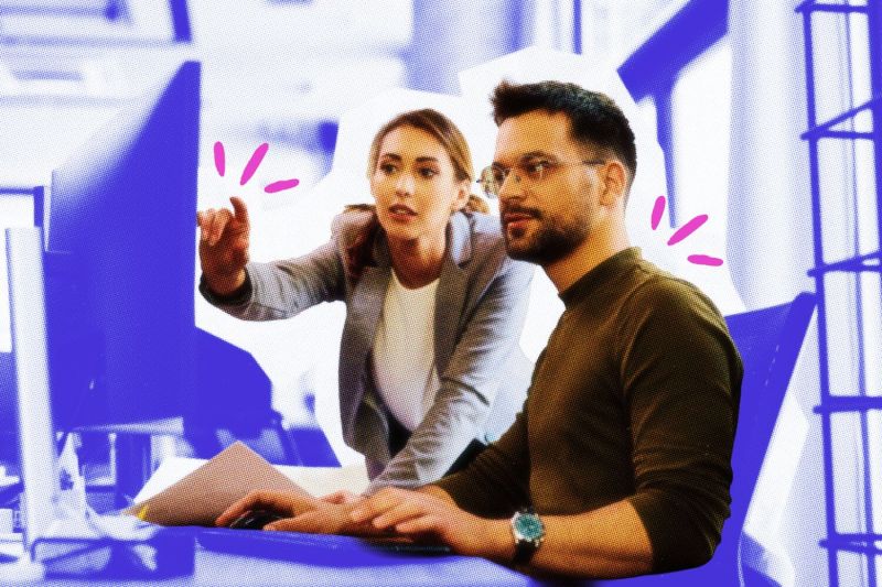 Two business owners talking while looking at a computer screen.